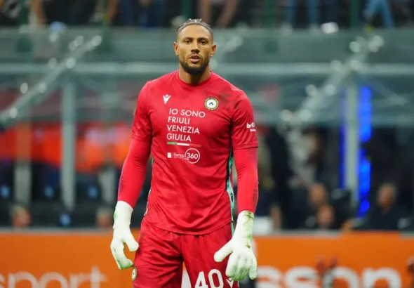 Maduka Okoye, Nigerian goalkeeper for Udinese Calcio, wearing the red number 40 goalkeeper kit with “IO SONO FRIULI VENEZIA GIULIA” and Banca 360 sponsors during a Serie A match.